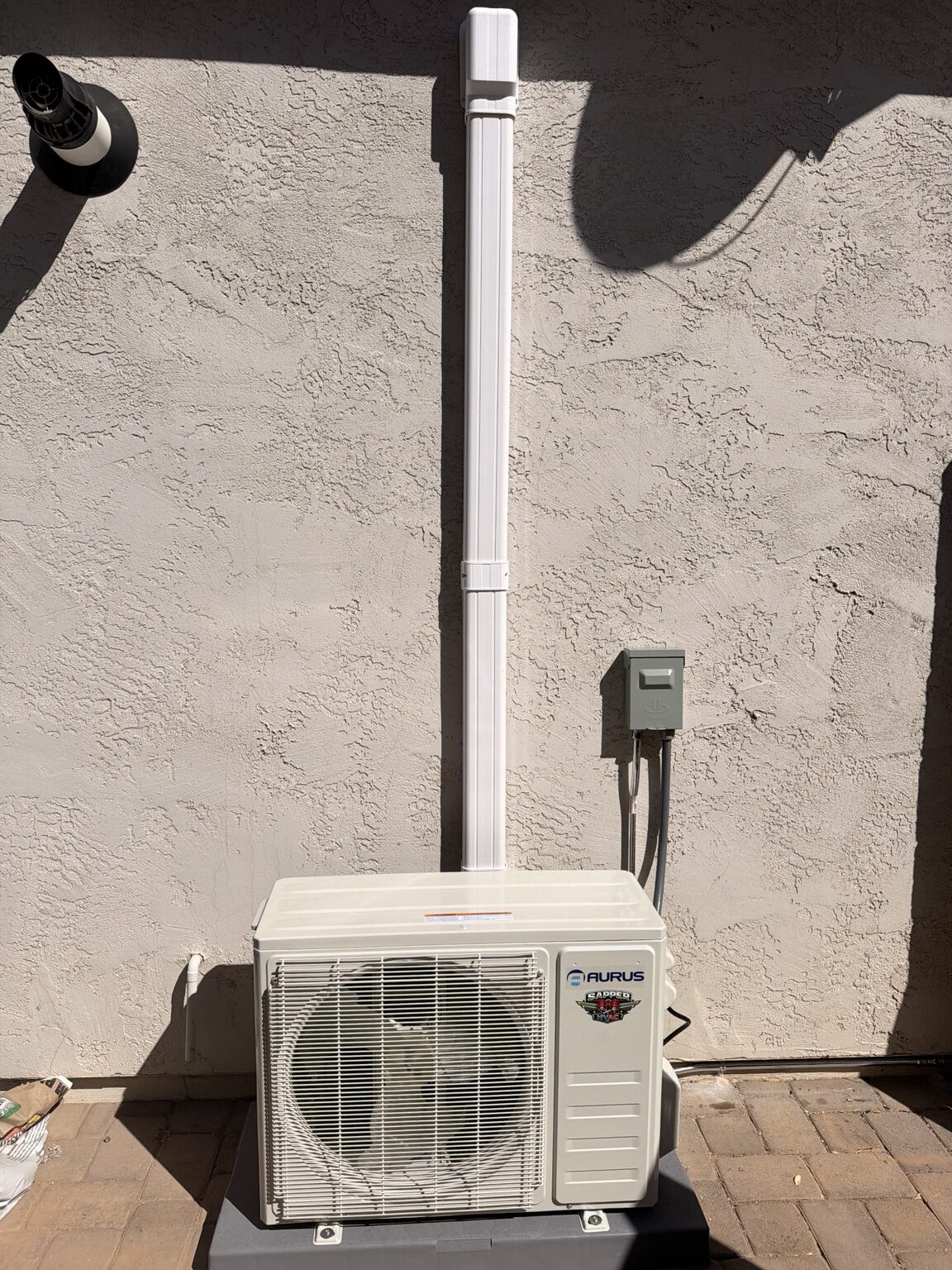 AURUS mini split condenser on pad with line set cover and disconnect in Litchfield Park Arizona